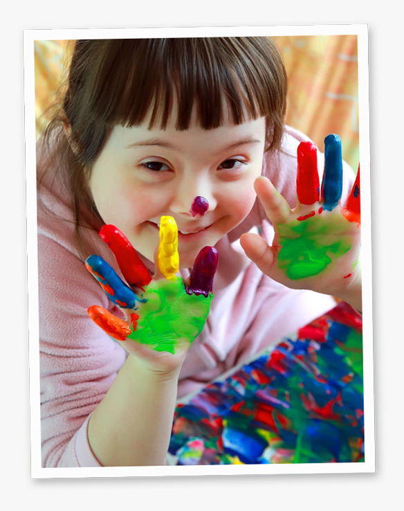 Photo of a smiling girl with paint on her hands