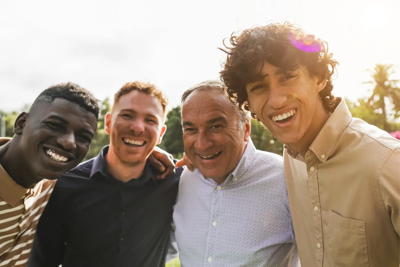 Multi-generational family smiling together outdoors, representing the importance of preparing younger generations for family wealth transfer planning and long-term legacy preservation.