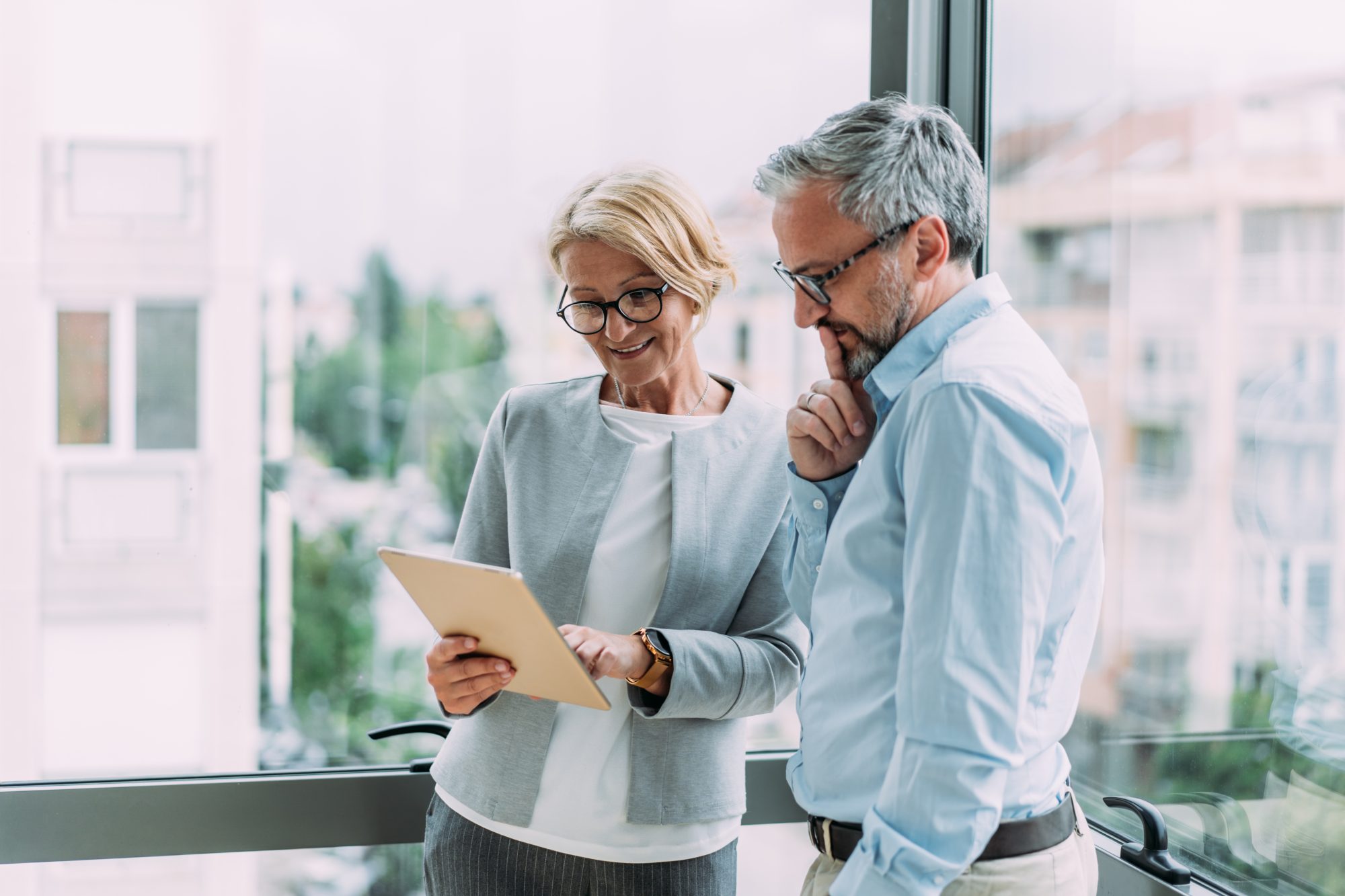 A photo of two professionals looking at documents in an office setting.